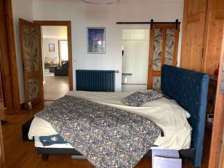 Experience comfort and style in this inviting bedroom, featuring a plush navy blue upholstered bed and a charming floral duvet.