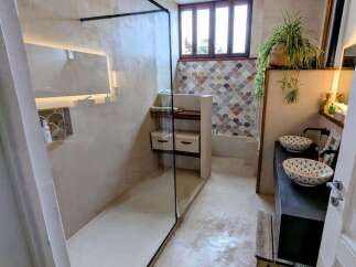 Experience modern luxury in this stunning bathroom featuring a spacious walk-in shower with a sleek glass enclosure and ambient lighting.