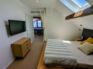 This charming bedroom offers a serene retreat with a comfortable bed adorned with a striped throw and accent pillows.