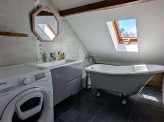This charming bathroom features a freestanding clawfoot bathtub, perfect for a relaxing soak.