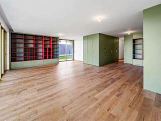 Discover this spacious room featuring a striking red-backed bookshelf and ample green built-in storage.
