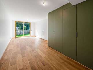 This spacious room features a large sliding glass door that opens to a lush green backyard, perfect for enjoying the outdoors.