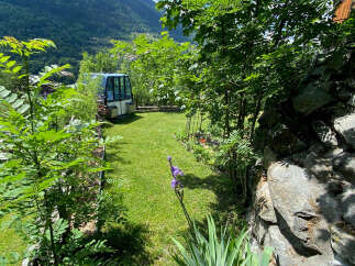 Discover this charming property nestled in a picturesque mountain setting, featuring a unique gondola cabin as a potential guest house or office space.