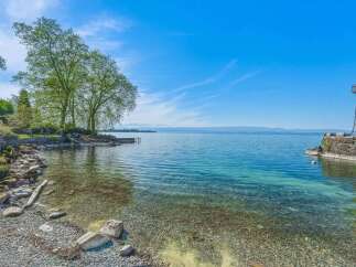 Experience serene lakeside living with this stunning property featuring a picturesque shoreline and crystal-clear waters.