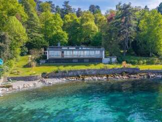 Experience luxury living with this stunning waterfront property, featuring a modern home with expansive windows offering breathtaking lake views.