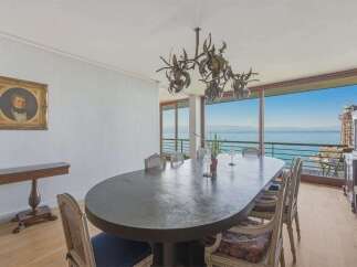 Experience breathtaking ocean views from this elegant dining room, featuring a large oval table perfect for gatherings.