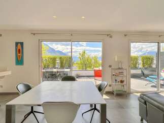 Experience breathtaking mountain views from this stunning dining and living area, featuring a spacious dining table perfect for gatherings.
