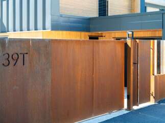 Experience modern living with this stunning property featuring a corten steel gate with house number '39T'.