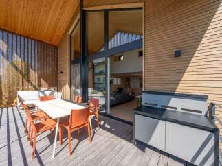 Experience modern living with this stunning balcony featuring a sleek dining set and a convenient outdoor grill station.