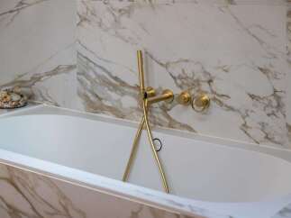 Indulge in luxury with this stunning bathroom featuring a freestanding bathtub and elegant marble-effect tiling.