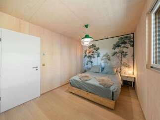 Experience a serene retreat in this charming bedroom, featuring a striking mural of trees that brings the outdoors in.