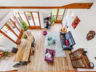 Experience modern living in this spacious open-concept living and dining area, featuring a large wooden dining table perfect for gatherings.