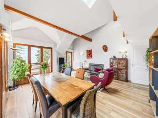 Experience breathtaking ocean views from this stunning living and dining area, featuring a large wooden dining table perfect for gatherings.