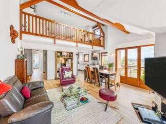 Discover this charming living space featuring a spacious open-plan layout with a cozy seating area and a dining space perfect for entertaining.