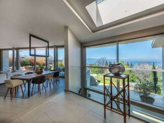 Experience luxurious living in this modern home featuring a spacious dining area with a striking geometric chandelier.