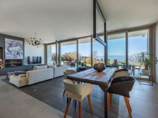 Experience modern living in this stunning open-plan space, featuring a sleek fireplace, comfortable sectional sofa, and a large dining area perfect for entertaining.