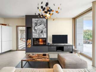 Experience modern living in this stunning open-concept living area, featuring a sleek fireplace with a captivating elephant artwork above.