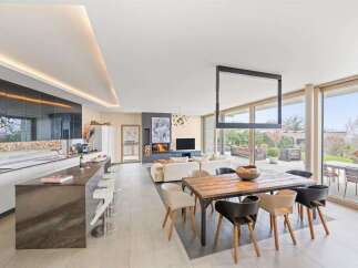 Experience modern luxury in this open-concept living space, featuring a sleek gourmet kitchen with a waterfall island and a spacious dining area perfect for entertaining.