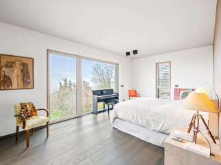 Experience luxury and comfort in this stunning bedroom, featuring a grand piano for musical inspiration and expansive windows that flood the space with natural light.