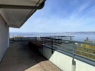Enjoy breathtaking panoramic views of the lake and distant mountains from this expansive rooftop terrace.