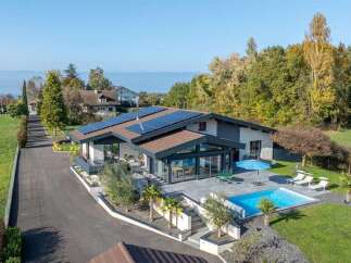 Experience modern luxury in this stunning home featuring a sleek design with expansive glass windows and a private swimming pool.