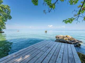 Enjoy serene lakefront living with this stunning property featuring a private wooden dock perfect for swimming, sunbathing, or launching your kayak.