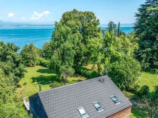 Experience breathtaking lake views from this stunning property, nestled amidst lush greenery and mature trees.