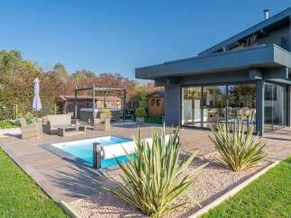 Experience luxurious outdoor living with this stunning property featuring a modern swimming pool and a relaxing hot tub, perfect for unwinding.