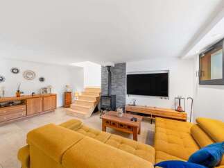 Experience modern living in this spacious living room featuring a cozy fireplace and a large flat-screen TV.