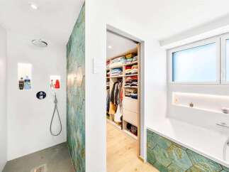 Discover a luxurious bathroom featuring a modern walk-in shower with recessed shelving and a striking hexagonal tile accent wall.
