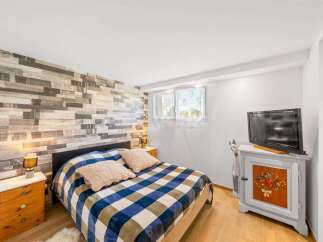 This charming bedroom features a unique accent wall with a rustic wood plank design, creating a warm and inviting atmosphere.
