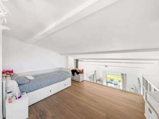This charming loft bedroom features a cozy daybed with ample storage drawers, perfect for maximizing space.