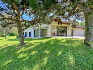 Discover this charming single-story home nestled amidst lush greenery and mature trees, offering a serene and private retreat.