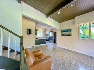 Discover this charming home featuring a spacious living area with a cozy leather armchair, perfect for relaxing.