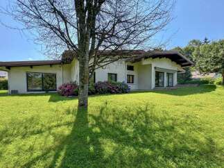 Discover this charming single-story home nestled in a serene, green landscape.