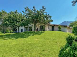 Nestled on a lush green hillside, this charming property offers a serene retreat with breathtaking mountain views.