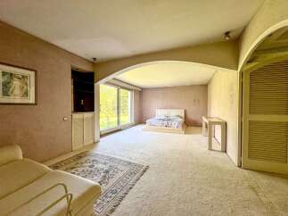 Discover this spacious bedroom featuring a comfortable king-size bed with a modern platform base, perfect for relaxation.