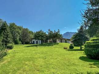 Nestled amidst lush greenery and mature trees, this stunning property offers a serene retreat with breathtaking mountain views.