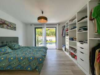 Experience modern living in this spacious bedroom featuring a vibrant, patterned duvet and a large, built-in closet.