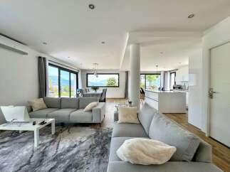 Experience modern living in this spacious open-plan home, featuring a sleek kitchen island and a comfortable living area with stunning mountain views.