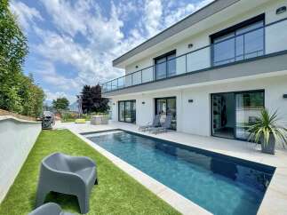 Experience modern luxury in this stunning property featuring a sleek infinity pool and expansive patio perfect for entertaining.