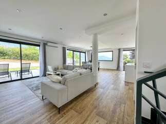 Experience modern living in this spacious open-plan home, featuring a comfortable living area with plush sofas and a sleek dining space.