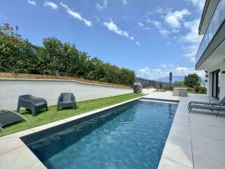 Experience luxury outdoor living with this stunning swimming pool and modern patio area.
