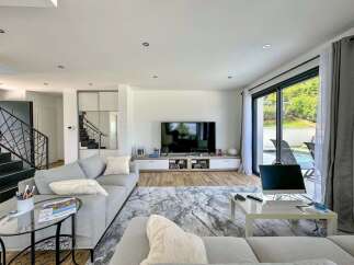 Experience modern living in this spacious open-plan living area, featuring a large sectional sofa and a sleek entertainment center.