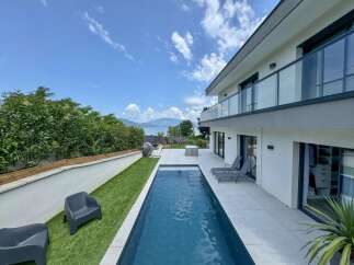 Experience luxury living with this stunning modern home featuring a sleek infinity pool and expansive patio perfect for entertaining.