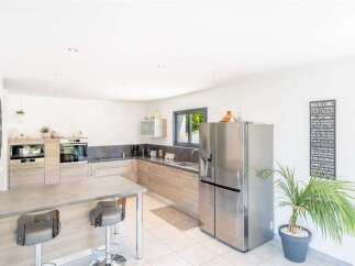 Discover this modern and spacious kitchen featuring sleek stainless steel appliances, including a large side-by-side refrigerator and built-in ovens.
