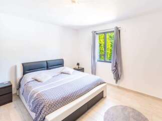 This inviting bedroom features a comfortable king-size bed with a sleek, modern headboard, perfect for relaxation.
