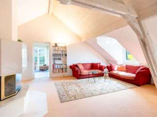 Experience comfort and style in this spacious living room, featuring two plush red sofas perfect for relaxation and entertaining.