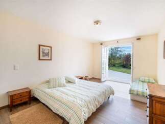 This charming bedroom offers a comfortable retreat with two beds, perfect for families or guests.