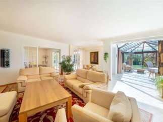Experience spacious living in this beautifully appointed home, featuring a bright and airy living room with comfortable seating and a large wooden coffee table.
